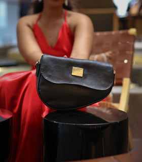 Denri Africa's black Montana Sling Bag. Polished black vegan leather sling, small travel-ready bag.