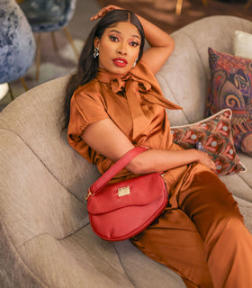 Denri Africa's red Montana Sling Bag. Modern sling bag in vibrant red, hands-free crossbody style, travel-ready.