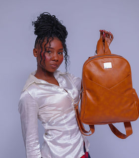 Denri Africa's caramel Monah Backpack. Classic caramel everyday backpack, water‑resistant finish, versatile carry for books or laptop.