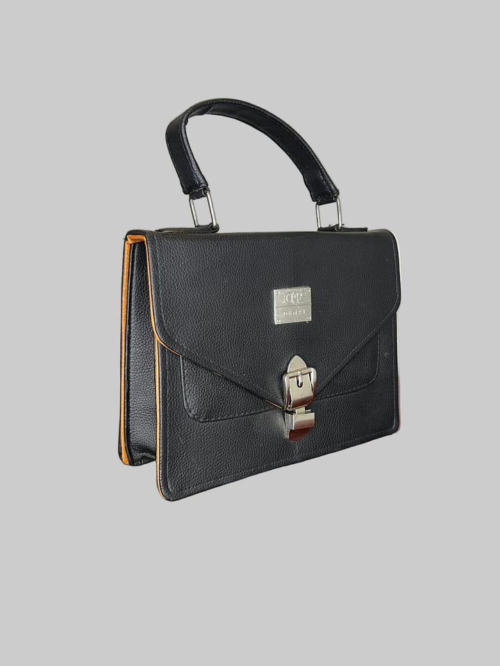 Black handbag on a wooden surface with a plain background